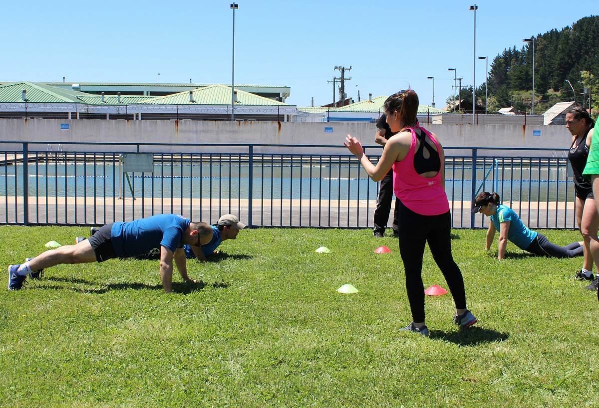 Group doing fitness classes packages on outdoor in rugged forest terrain
